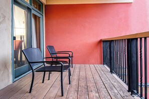 Un balcon avec deux chaises et un plancher en bois.