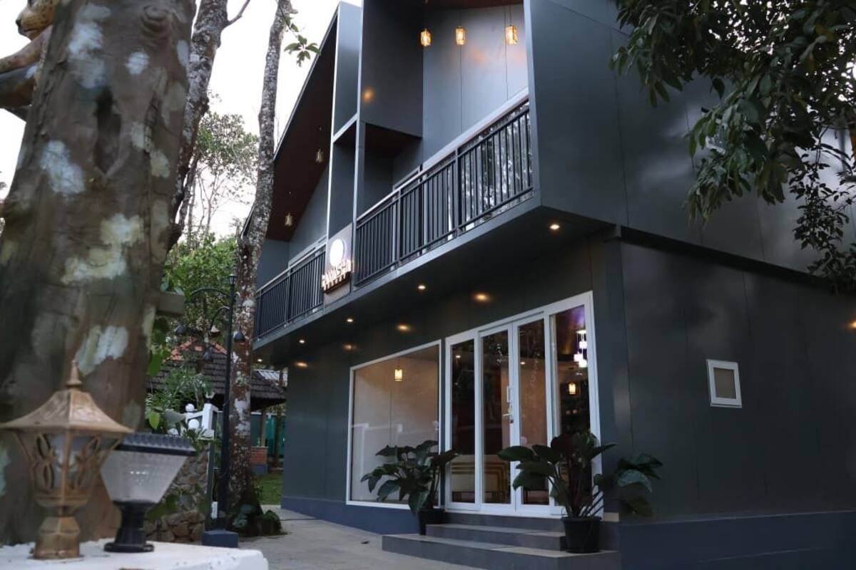 Un edificio moderno con un balcone, ampie finestre e piante in vaso.
