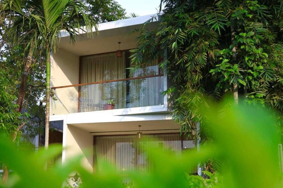 Un edificio moderno a due piani con ampie finestre e un balcone.