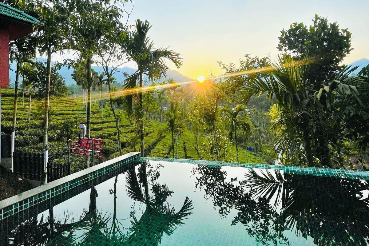 Una piscina a sfioro con vista su un tramonto e un giardino a terrazze.
