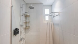 A modern shower with a handheld showerhead, a wall-mounted faucet, and a glass shower enclosure. - Brassbell Zamalek Daoud Studios Villa A (Cairo)