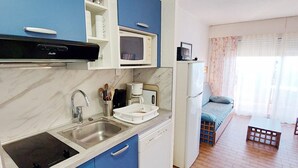 Une cuisine compacte équipée d’un four à micro-ondes, d’une machine à café et d’un réfrigérateur.