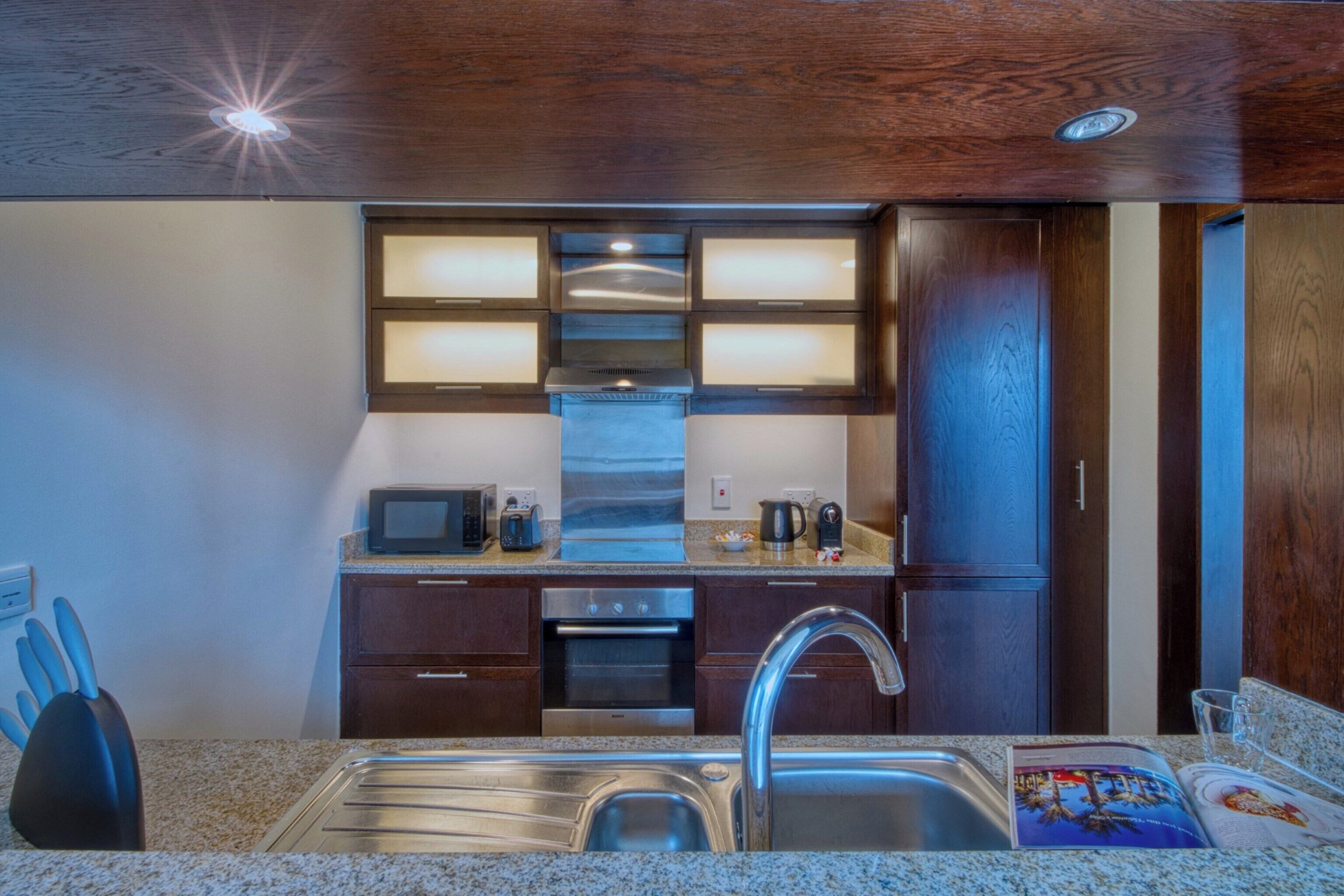 A modern kitchen with granite countertops, stainless steel appliances, and wooden cabinets.