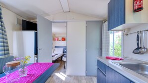 A compact kitchen with a sink, cabinets, and a window.