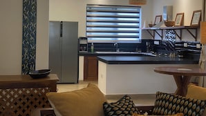 Eine moderne Küche mit Einbaukühlschrank, Spüle und Essbereich mit Tisch und Stühlen.