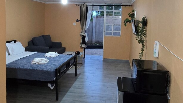 Une chambre d’hôtel équipée d’un lit, d’un bureau et d’une kitchenette.