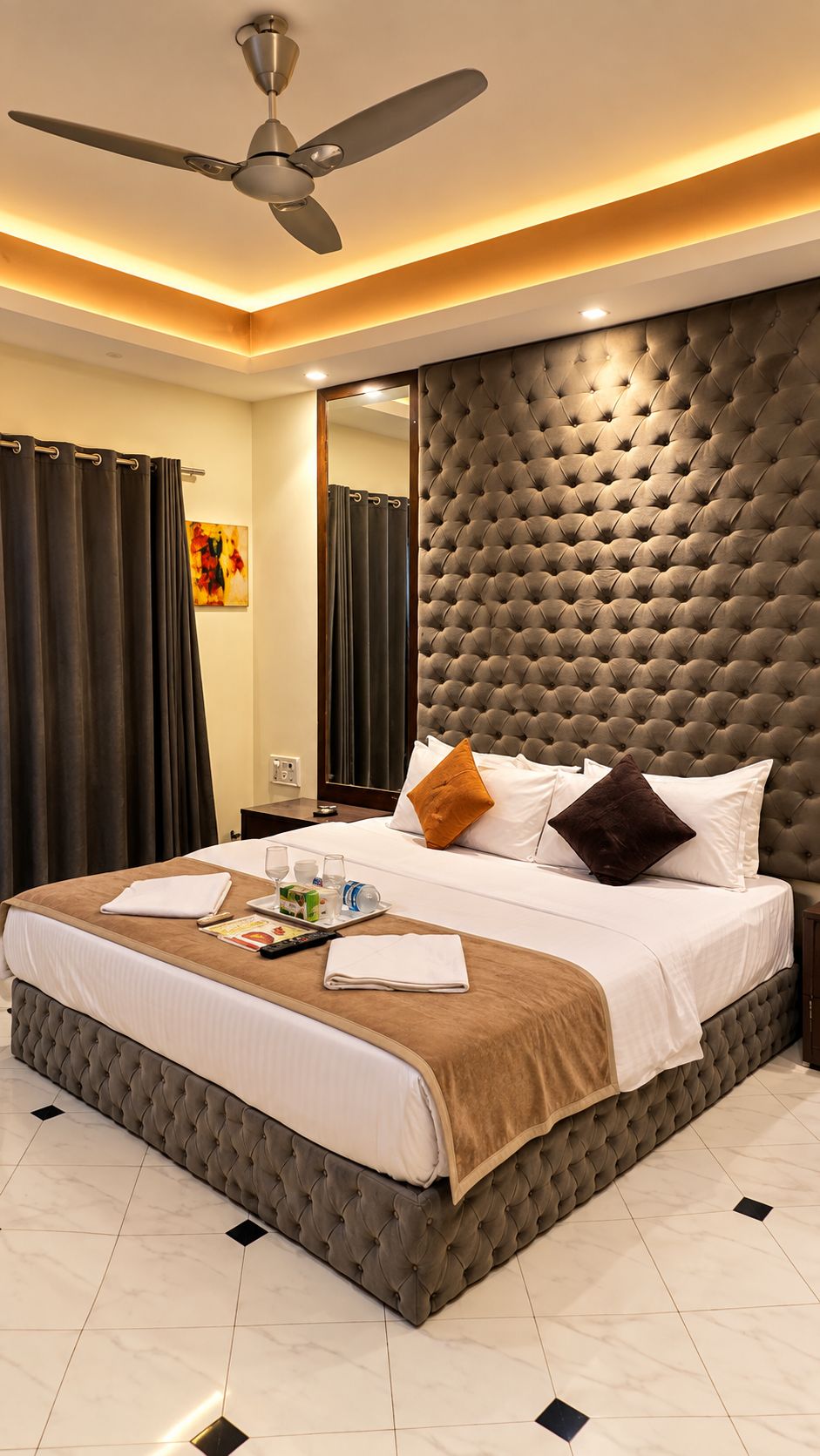 Une chambre d’hôtel dotée d’un grand lit, d’un ventilateur de plafond et d’un design moderne.