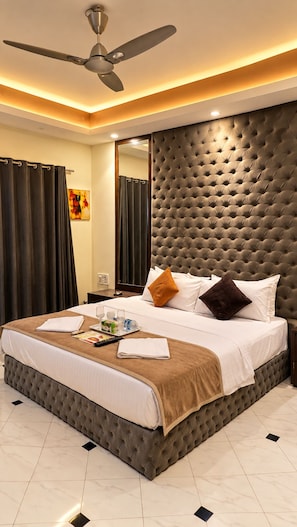 Une chambre d’hôtel dotée d’un grand lit, d’un ventilateur de plafond et d’un design moderne.