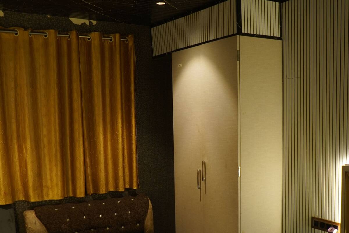 Ein Hotelzimmer mit Bett, Sofa, Schrank, Schreibtisch und Spiegel.