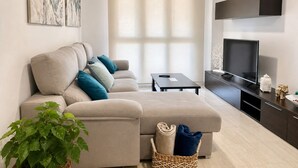 A modern living room with a sofa, a TV, and a small table. - APARTMENT WITH SEA VIEW (Viveiro)