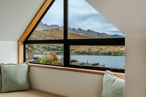 A room with a large window offering a view of a lake and mountains. - Elevated Outlook - Close to Town - Lake Views (Queenstown)