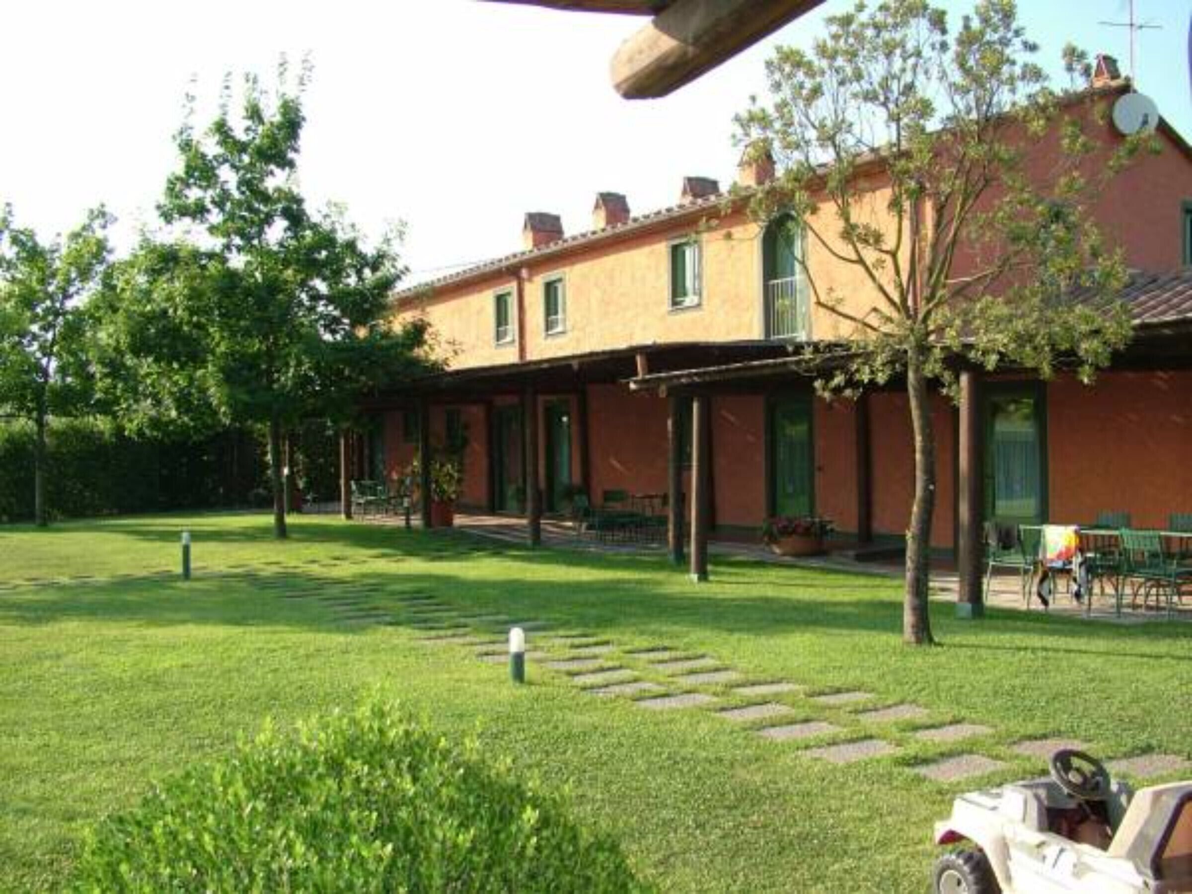 Un bâtiment doté d’un jardin, d’un espace extérieur aménagé pour s’asseoir et d’une pelouse.
