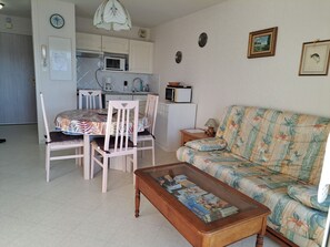 A compact living space with a dining area, kitchenette, and a sofa. - Apt 4 pers, south-facing balcony, pets welcome - Fort-Mahon-Plage (Fort-Mahon-Plage)