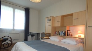 Ein Schlafzimmer mit einem Bett, einem Schreibtisch und Bücherregalen.