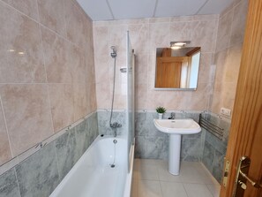 A bathroom with a bathtub, a shower, a sink, and a mirror. - Charming house in L'Escala with communal pool (L'Escala)