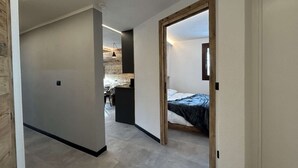Un intérieur moderne avec un couloir menant à une chambre et à un coin repas.