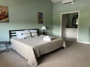 A neatly made bed with a white comforter and pillows, a bedside lamp, and a poster on the wall. - Fairway Villa 406 at Rumbling Bald (Lake Lure)