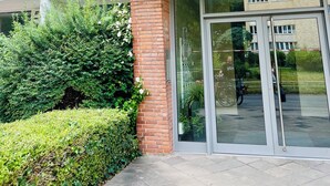 Ein mehrstöckiges Gebäude mit Ziegelaußenwand, großen Glas-Eingangstüren und einem überdachten Zugang.