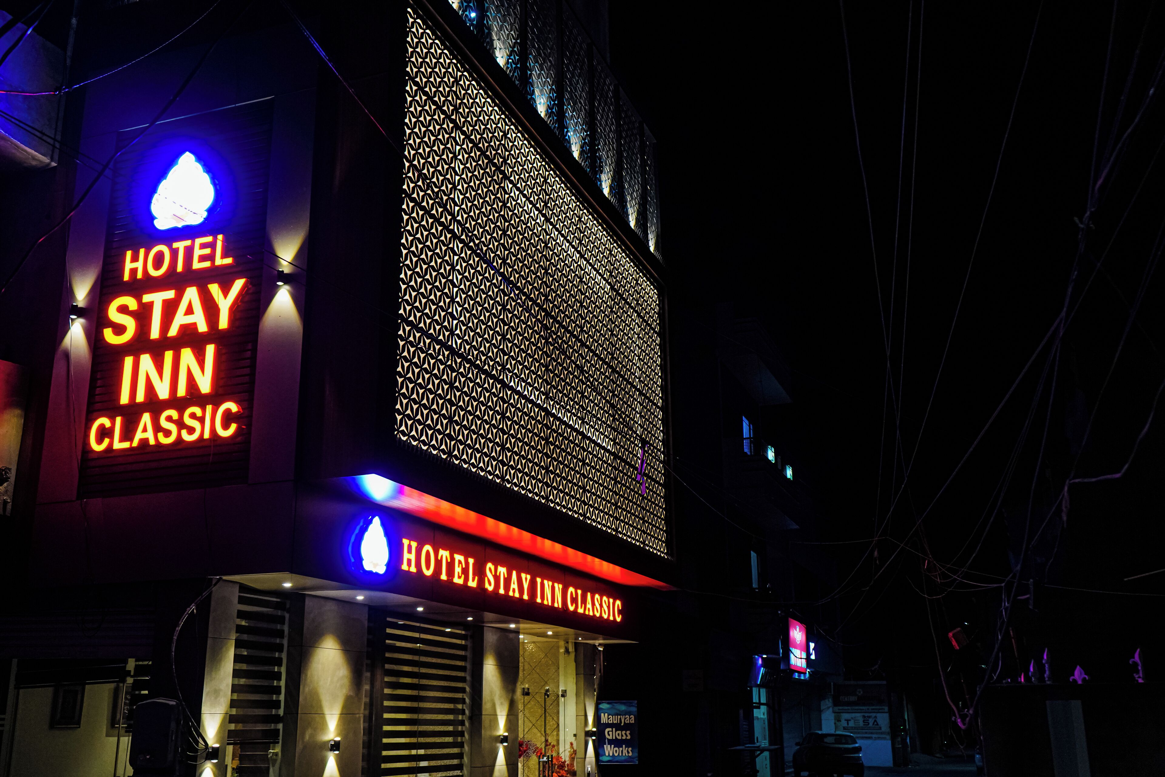 A hotel sign with "HOTEL STAY INN CLASSIC" and a large illuminated window display.