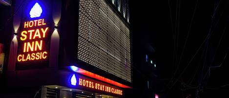 A hotel sign with "HOTEL STAY INN CLASSIC" and a large illuminated window display.