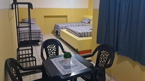 A dormitory room with two single beds, a small table with a potted plant, and a chair. - POUSADA SOLAR DOS LUSITANOS (São Luís)
