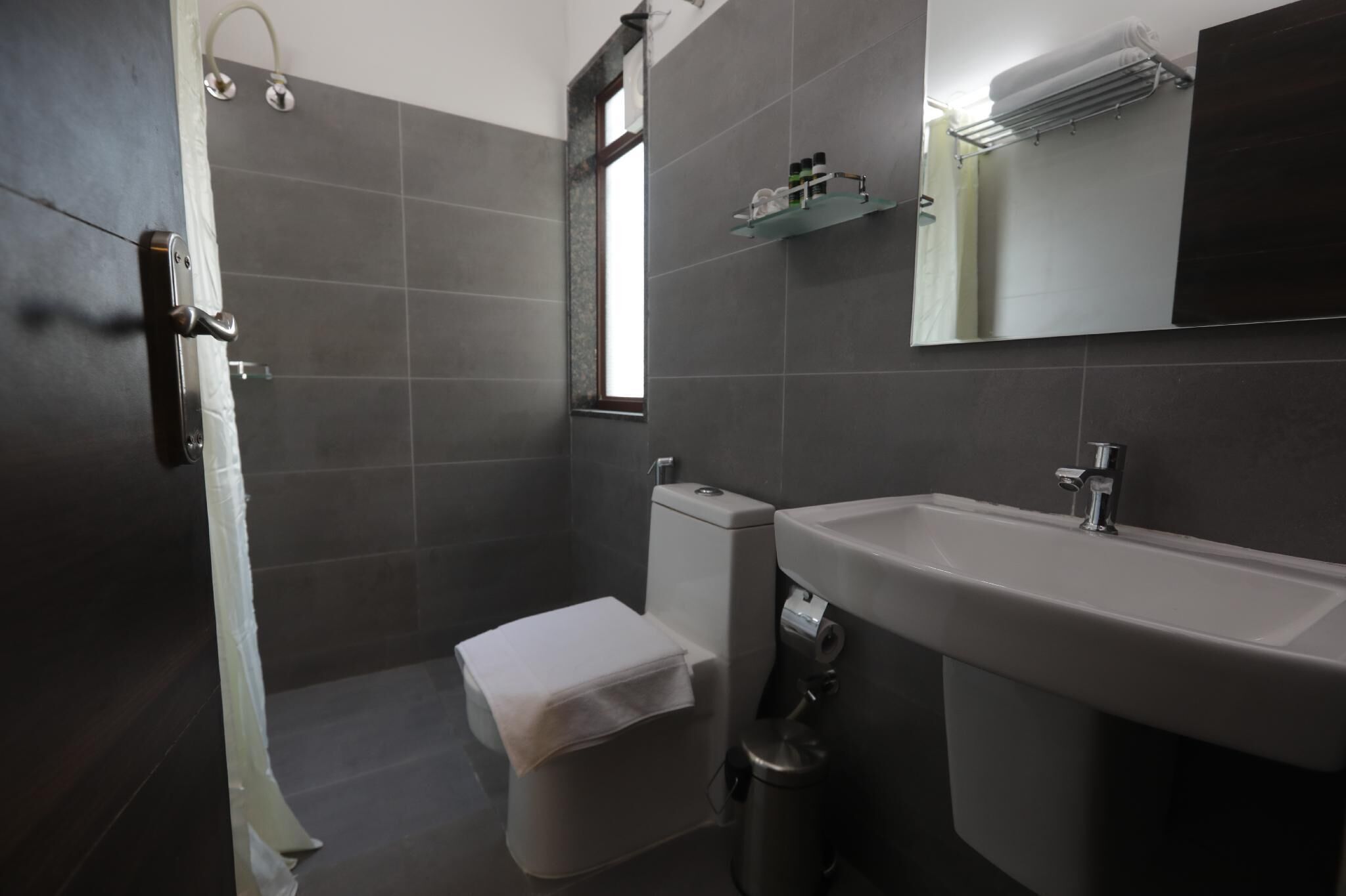 Une salle de bain avec des toilettes, un lavabo et une douche.