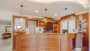 A reception desk with a wooden finish, a digital display, and a ticket counter. - Hotiday Peschiera Frassino (Broglie)