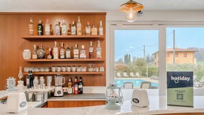 A bar area with shelves of liquor bottles, a coffee machine, and a sign for 'hotday' with a QR code. - Hotiday Peschiera Frassino (Broglie)