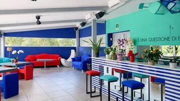 A modern interior with a bar area, seating, and potted plants.
