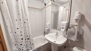 A bathroom with a bathtub, a sink, a toilet, and a shower curtain. - Apartment 3 (Pido)