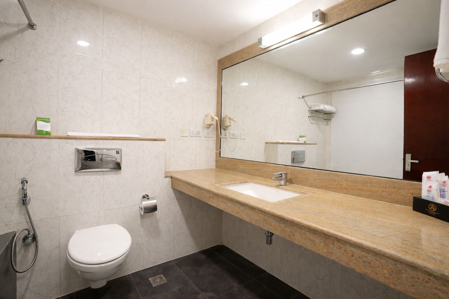 Un baño moderno con inodoro blanco, lavamanos y ducha.