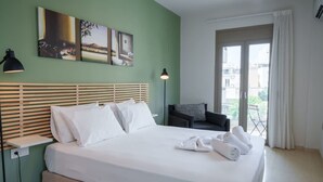 A hotel room with a bed, bedside tables, a sofa, and artwork on the wall. - Irakleio Notos Boutique Apartments 2 (Heraklion)