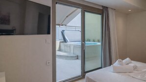 A hotel room with a bed, a TV, a sliding glass door leading to a balcony with a hot tub. - Irakleio Notos Boutique Aprtmnts 3 Private Jacuzzi (Heraklion)