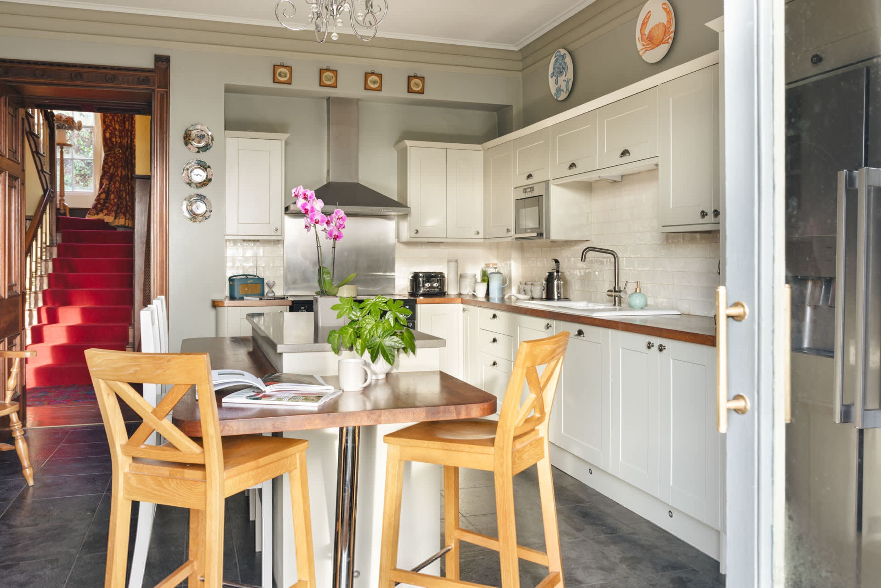 A modern kitchen with white cabinets, stainless steel appliances, and a central island with chairs.