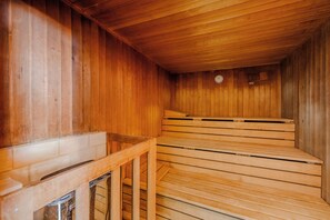 Una sauna de madera con un banco y un reloj en la pared.