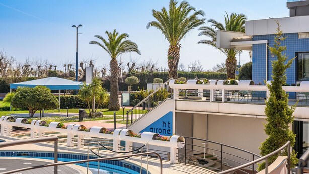 Una zona de piscina con una escalera que lleva a un edificio con la leyenda 'ht arone'.