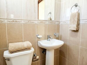 Ein Badezimmer mit Toilette, Waschbecken und Handtuchhalter.