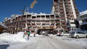 Un hotel a più piani con balconi, un bar e un ristorante.