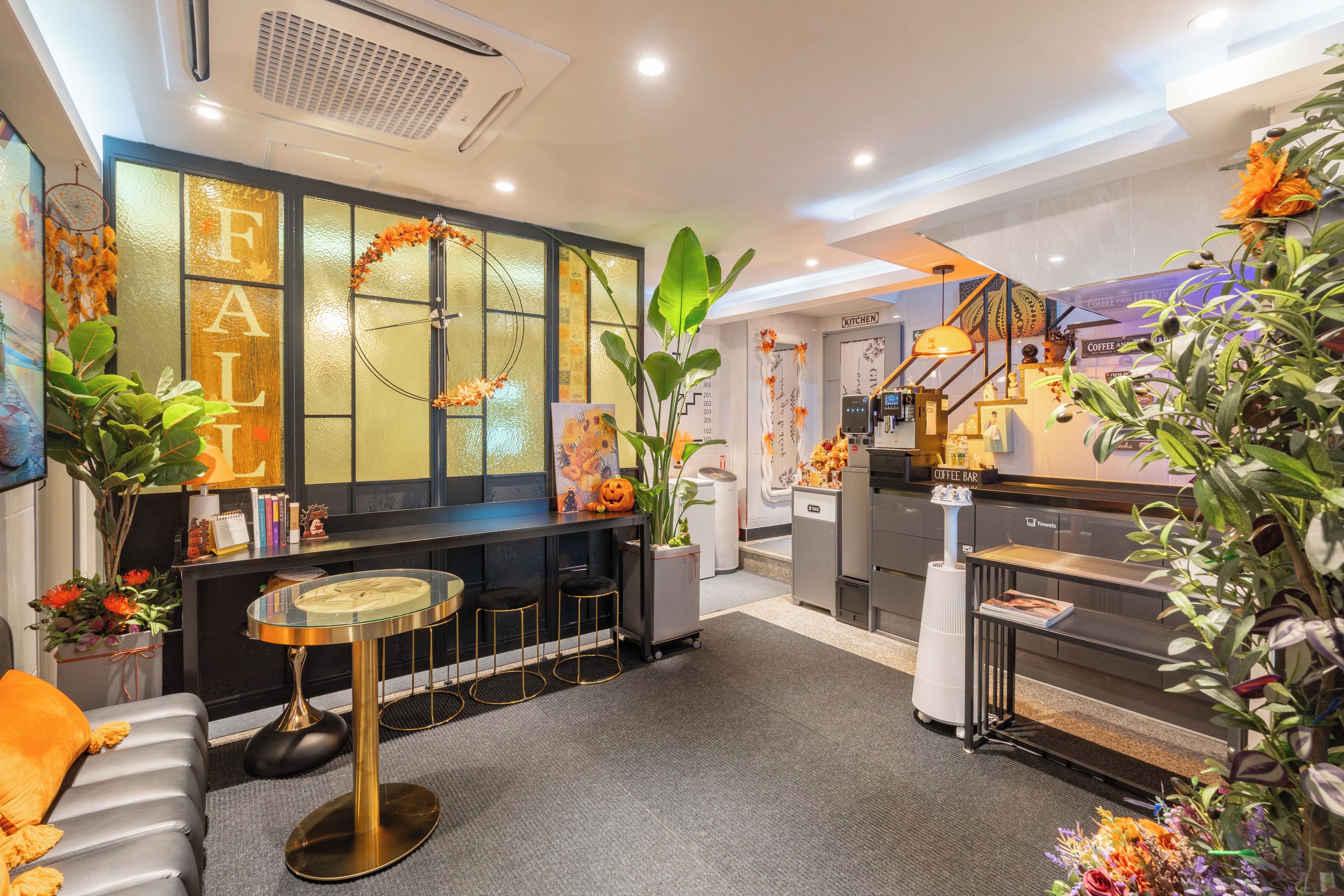 Un área de bar moderna con una mesa de vidrio, taburetes y una planta decorativa.