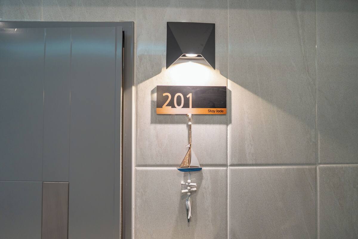 A wall-mounted sign with the number '201' and the text 'Stay Jade.'