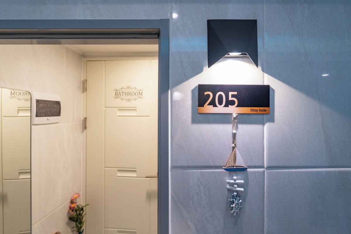 A bathroom with a sign reading '205 Stay jade' and a number '205' on the wall.