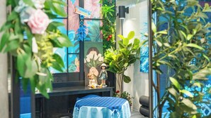 A room with a round table, a sofa, and a decorative plant arrangement. - STAY JADE (Seoul)