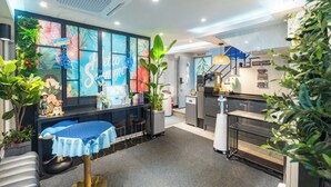 A modern kitchen with a coffee and tea bar, a dining area with a table and stools, and a kitchen counter. - STAY JADE (Seoul)