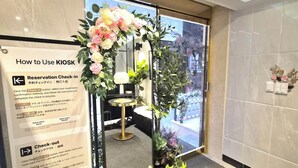 A reception area with a kiosk for reservations and check-in, a check-out button, and a check room number sign. - STAY JADE (Seoul)