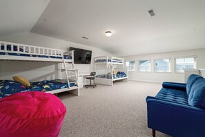 A room with bunk beds, a desk, a chair, a blue sofa, and a bean bag. - DOG FRIENDLY & ALL NEW-SLEEPS 10-POOL CMMTY ON CANAL-21 Canal Landing, Rehob. (Rehoboth Beach)