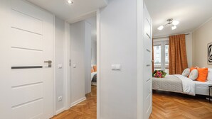 A modern bedroom with a bed, a nightstand, and a window with curtains. - Lumina cozy apartment in the city center (Warsaw)