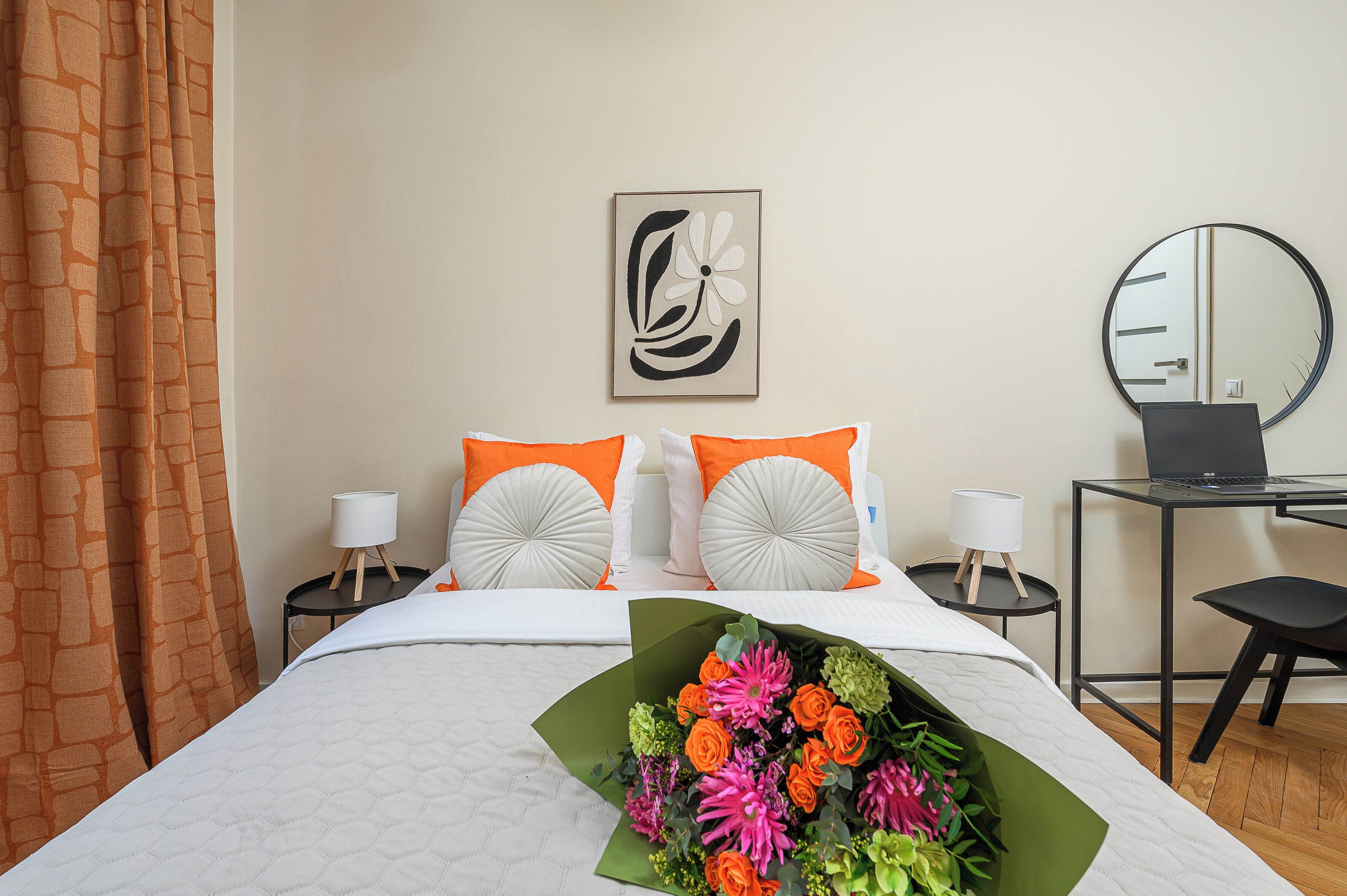Une chambre d’hôtel avec un lit, un bureau, une chaise et un miroir.