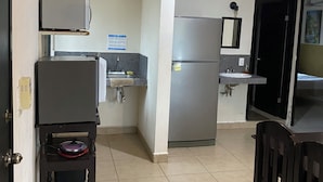 A compact kitchen with a refrigerator, sink, and a small table. - Luna Studios 23  (Bacalar)