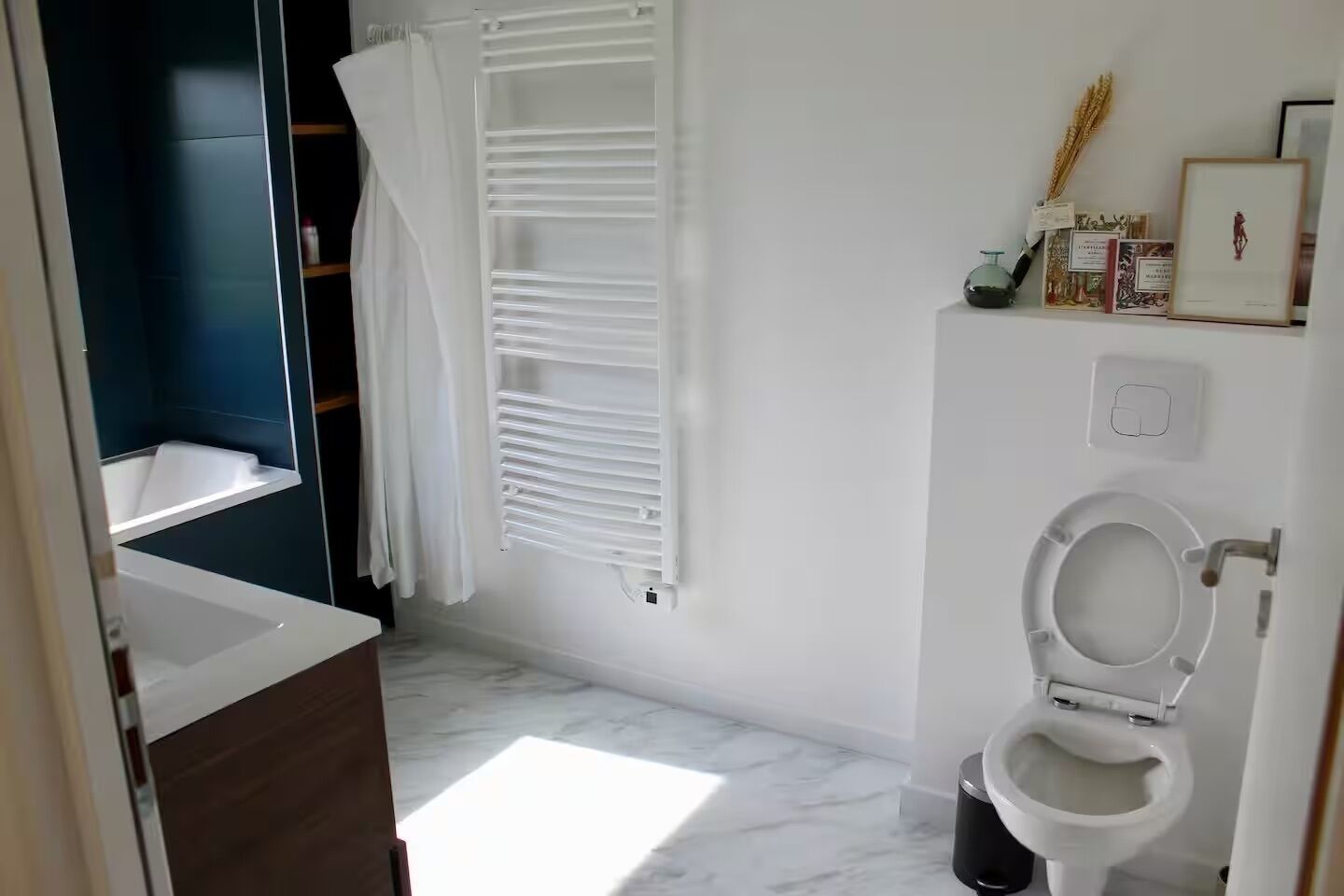 Casa de banho com banheira, sanita e cortina de chuveiro.