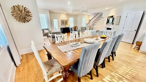 Un coin repas avec une table en bois, six chaises et un lustre.